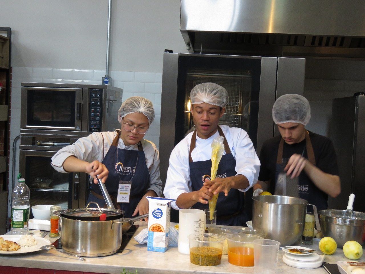 Um grupo de chefs está preparando comida em uma cozinha