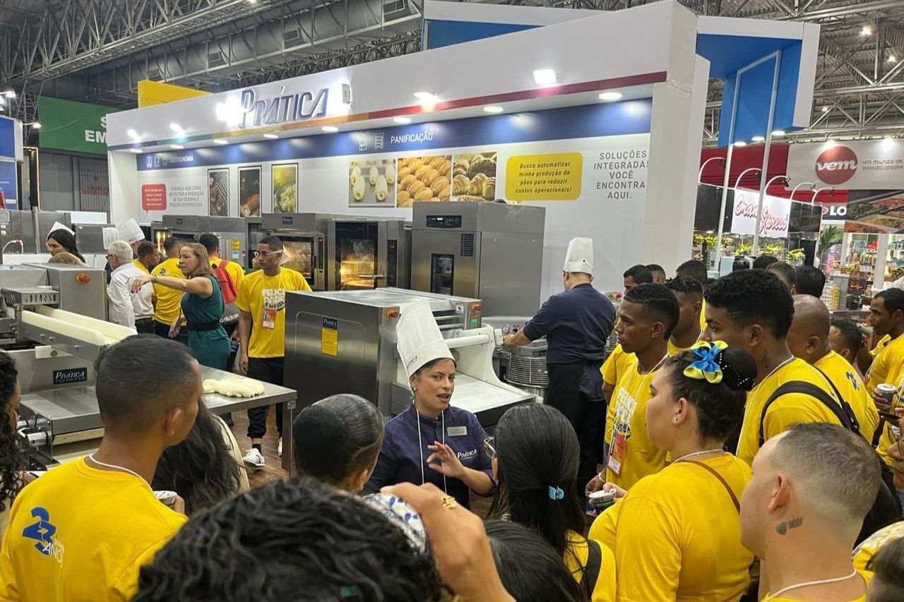 Um grupo de pessoas com camisas amarelas estão em uma sala.