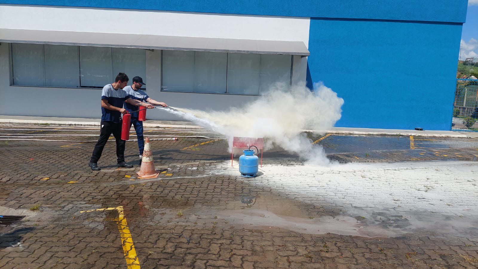 Dois homens estão usando um extintor de incêndio para apagar um incêndio.