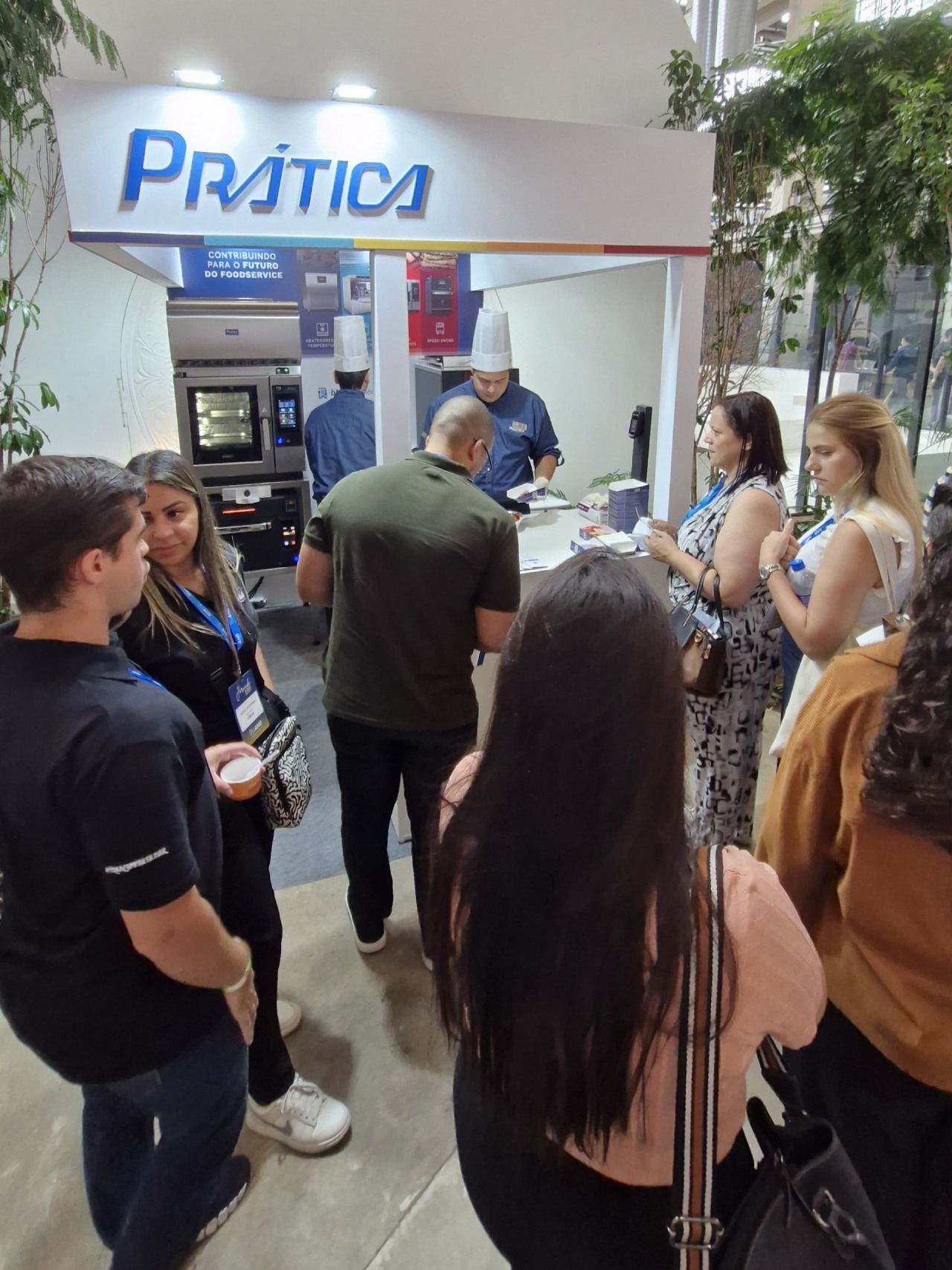 Um grupo de pessoas em pé em frente a uma placa de prática