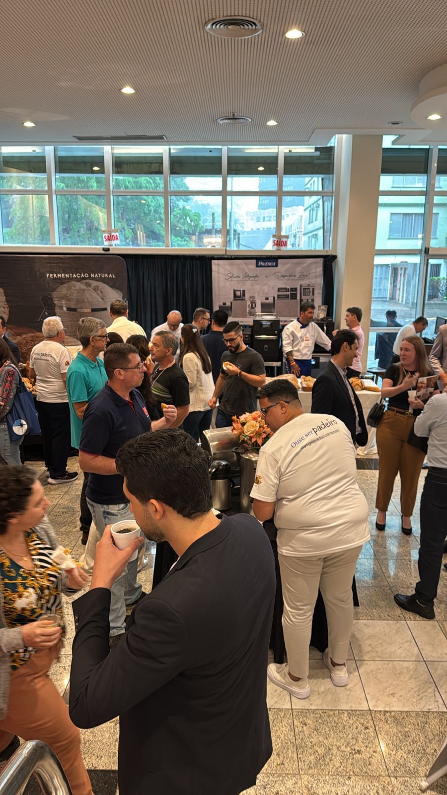 Um grupo de pessoas está em pé ao redor de uma mesa em uma sala.