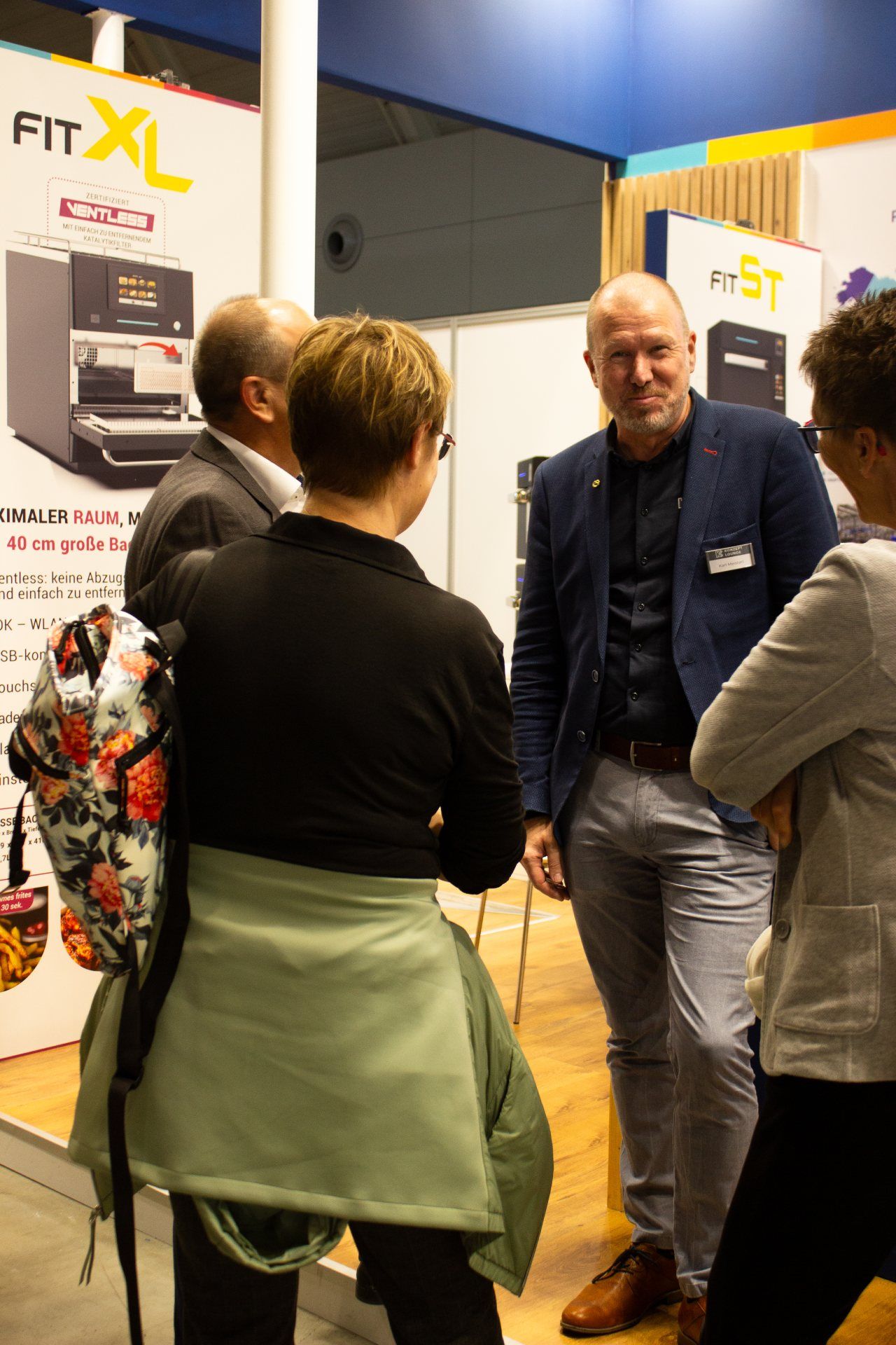 Um grupo de pessoas está em frente a uma placa que diz fit xl.