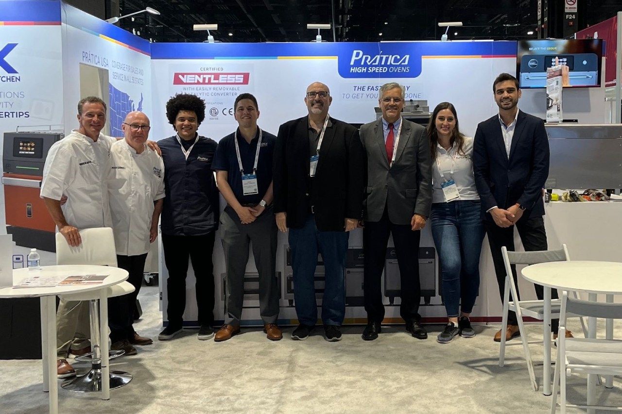 Um grupo de pessoas está posando para uma foto em frente a uma cabine.