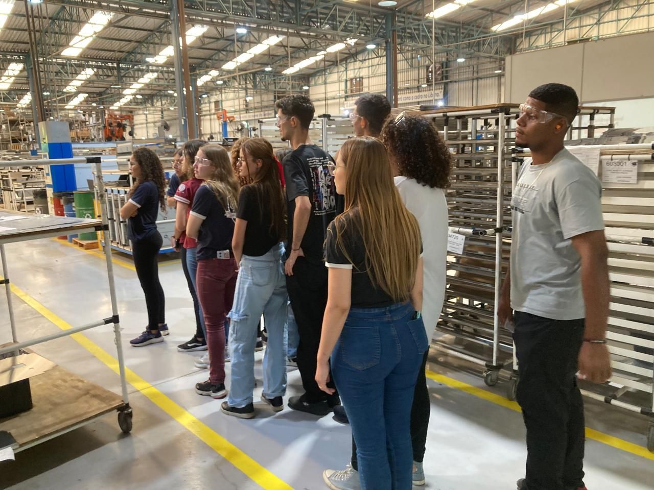 Um grupo de pessoas está em um armazém.