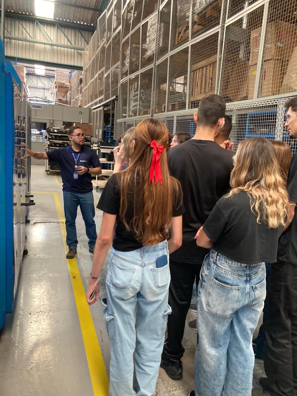 Um grupo de pessoas está em um armazém conversando com um homem.