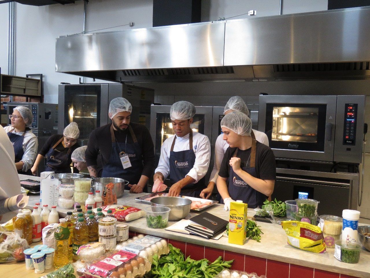 Um grupo de pessoas está preparando comida em uma cozinha.