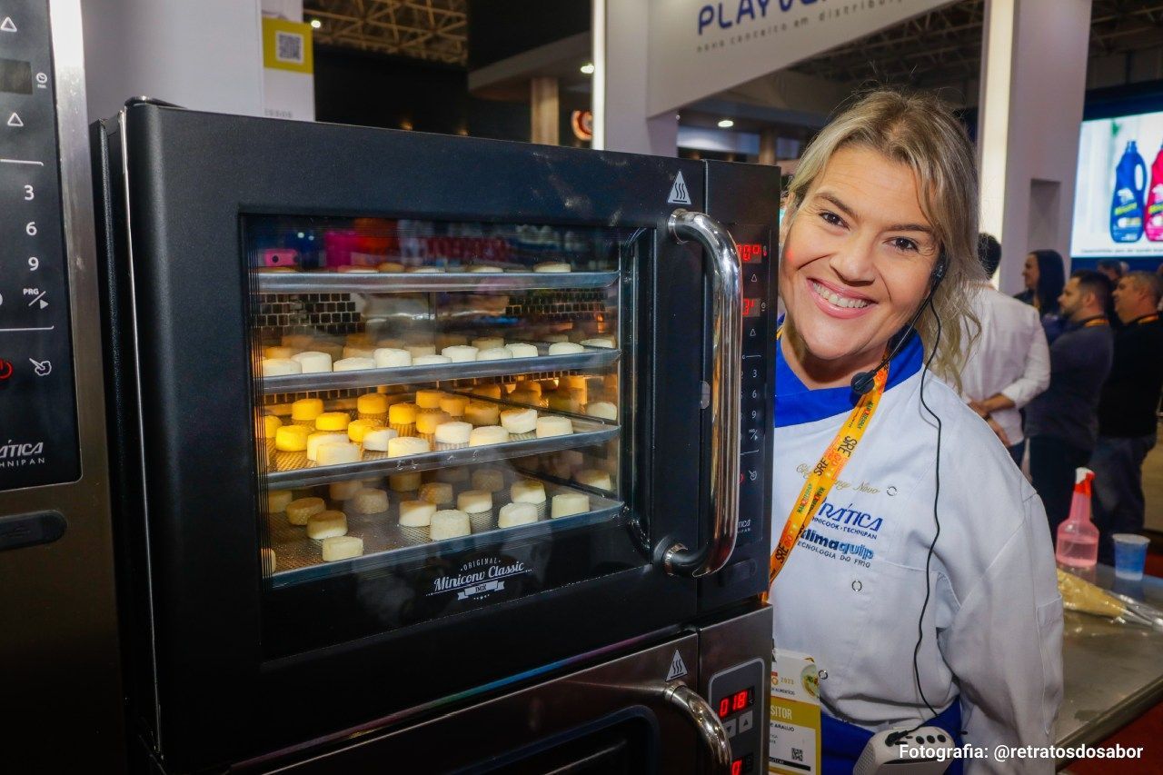 Uma mulher está parada em frente a um forno de micro-ondas cheio de comida.