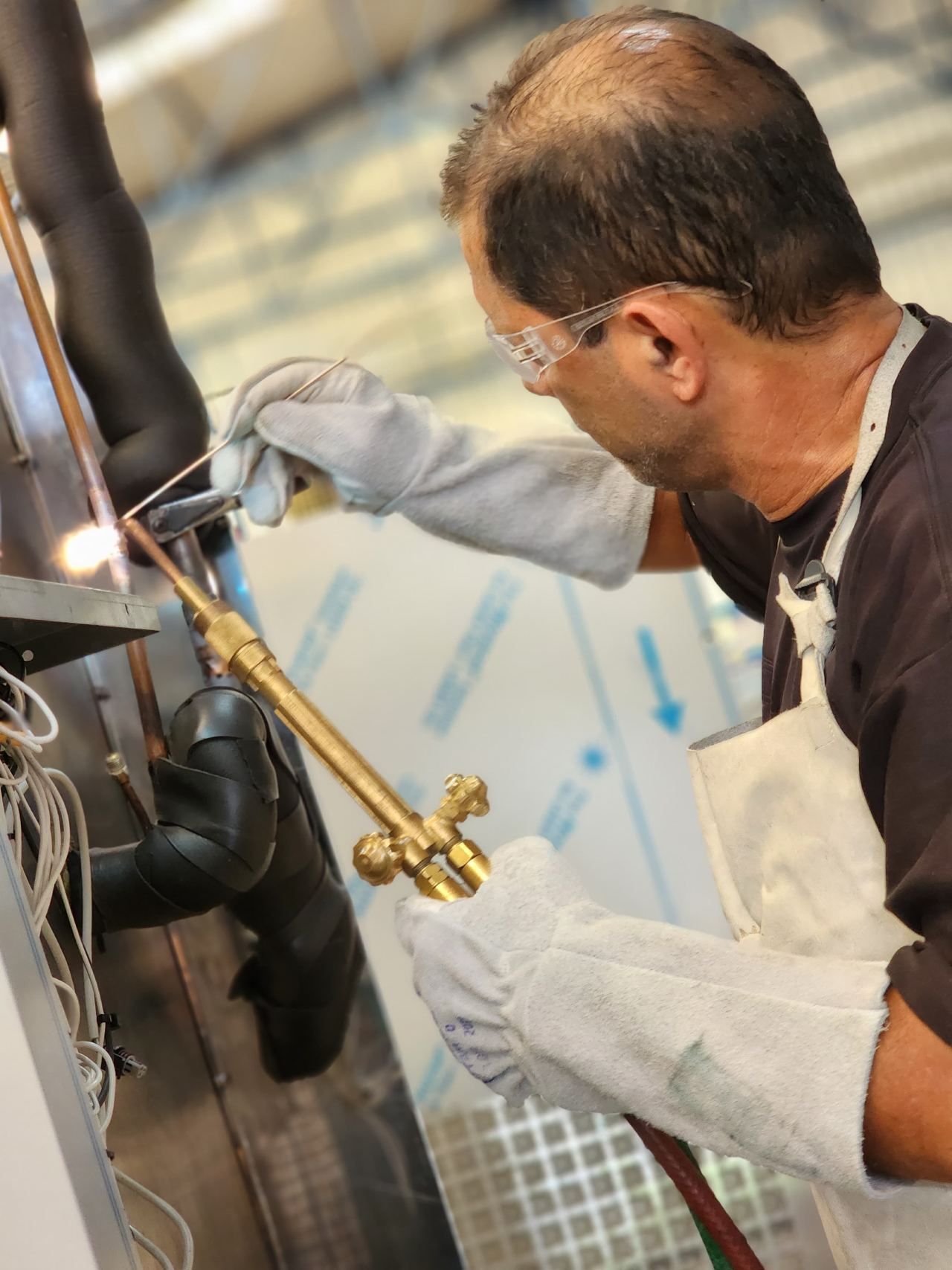 Um homem usando luvas está soldando um pedaço de metal
