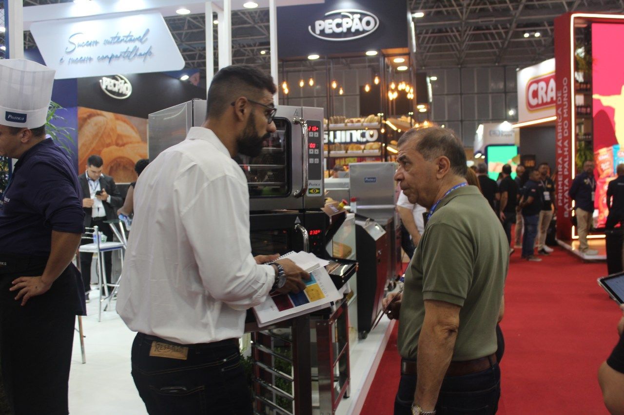 Um homem está conversando com outro homem em uma feira comercial.