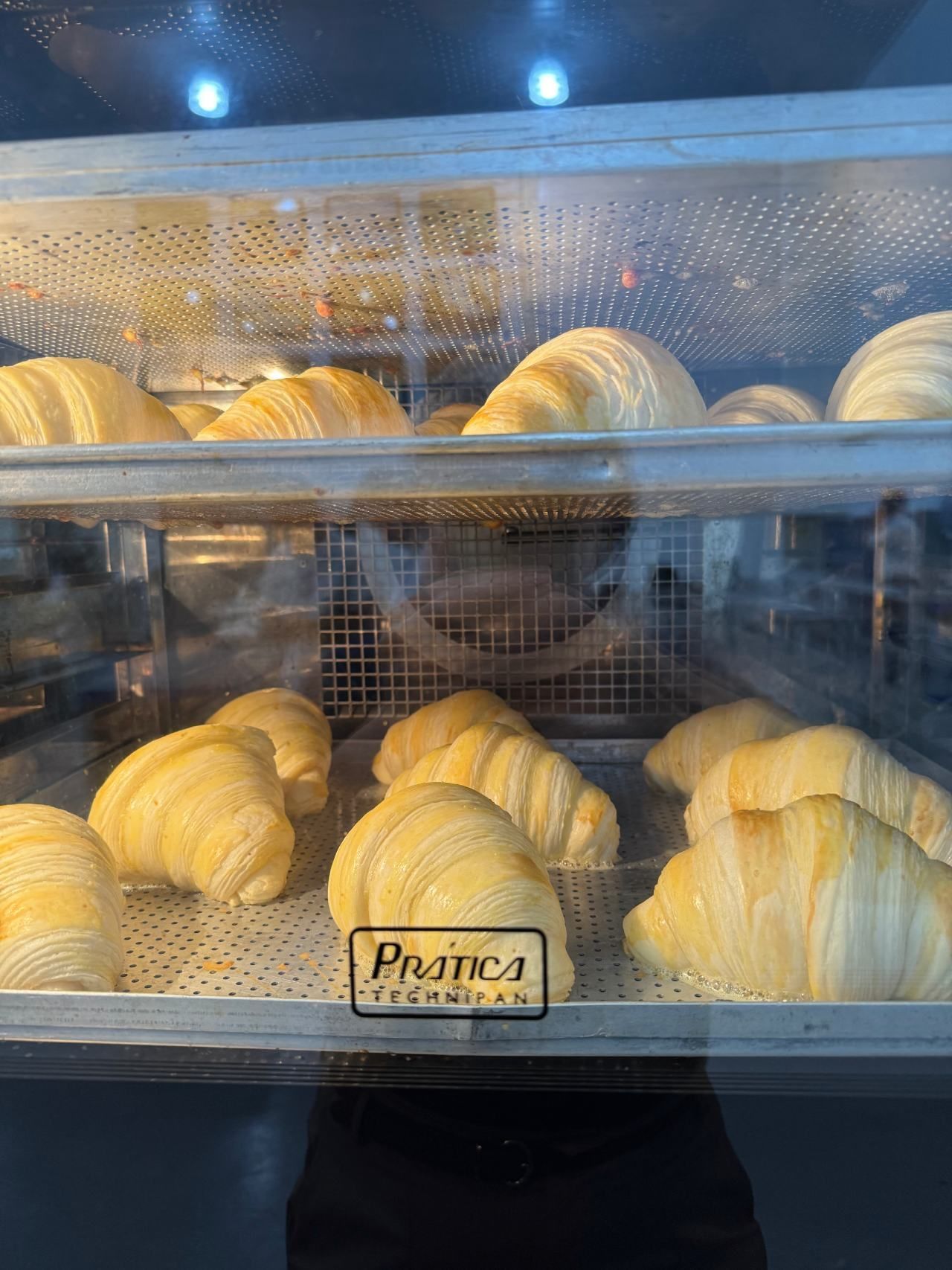 Uma vitrine cheia de croissants em uma padaria.