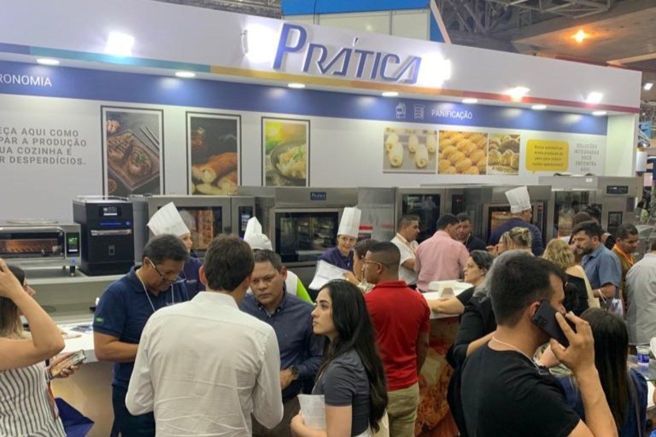 Um grupo de pessoas está em frente a uma cabine de prática.