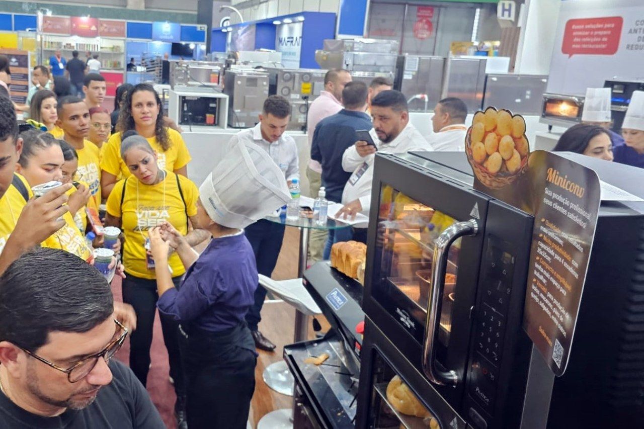 Um grupo de pessoas está em volta de um forno de micro-ondas.