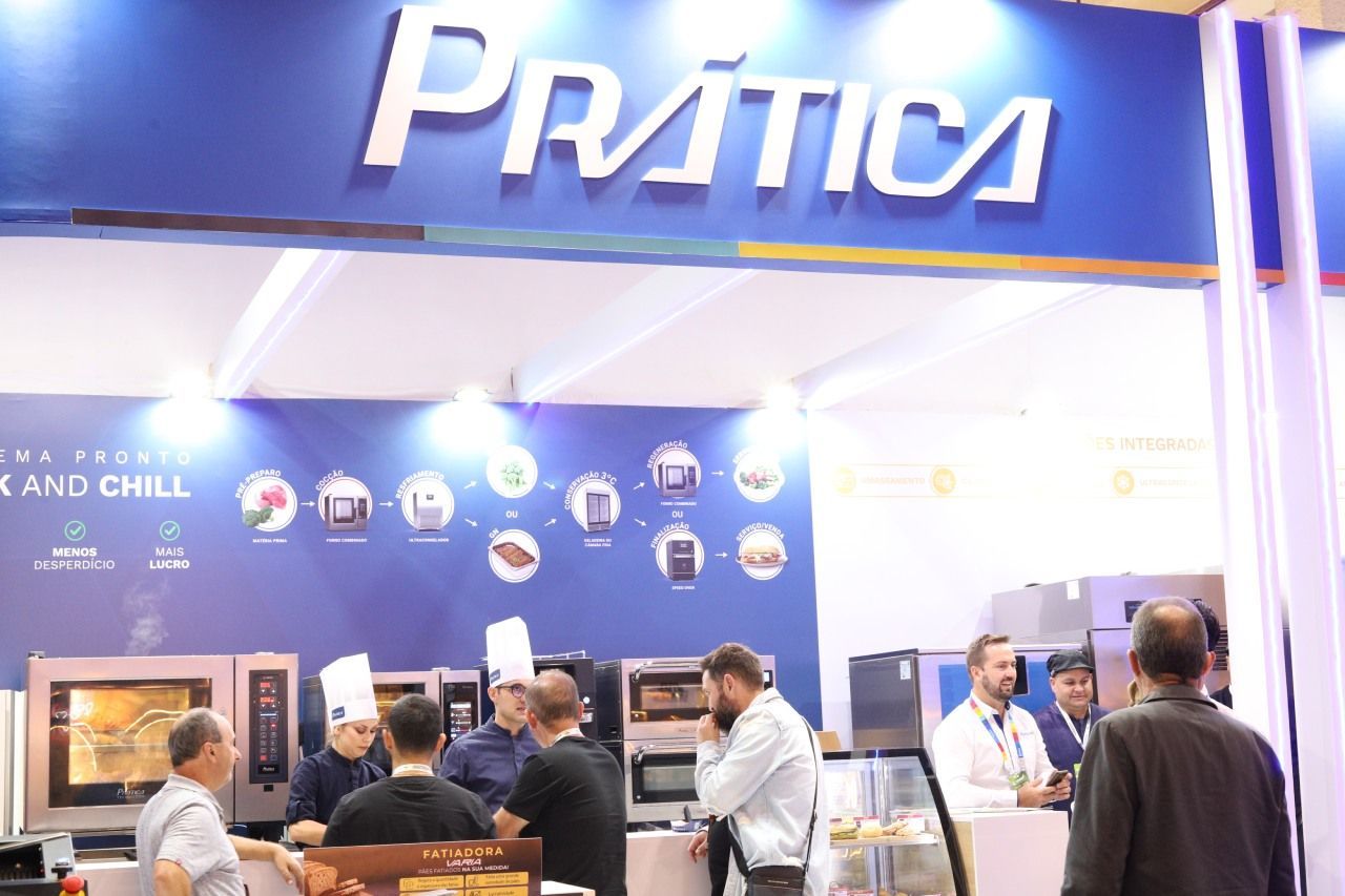 Um grupo de pessoas está parado sob uma placa de prática