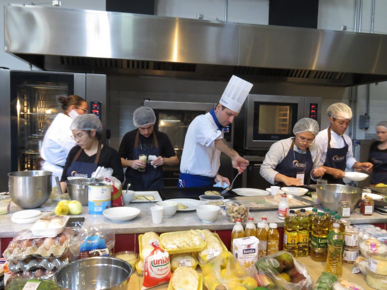 Um grupo de chefs está preparando comida em uma cozinha