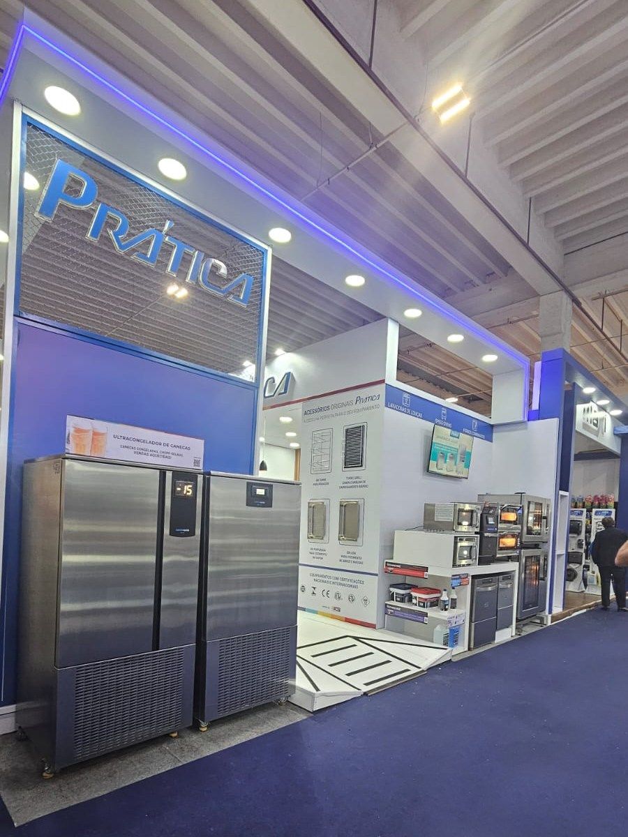 Uma geladeira de aço inoxidável está em frente a uma placa que diz príncipe