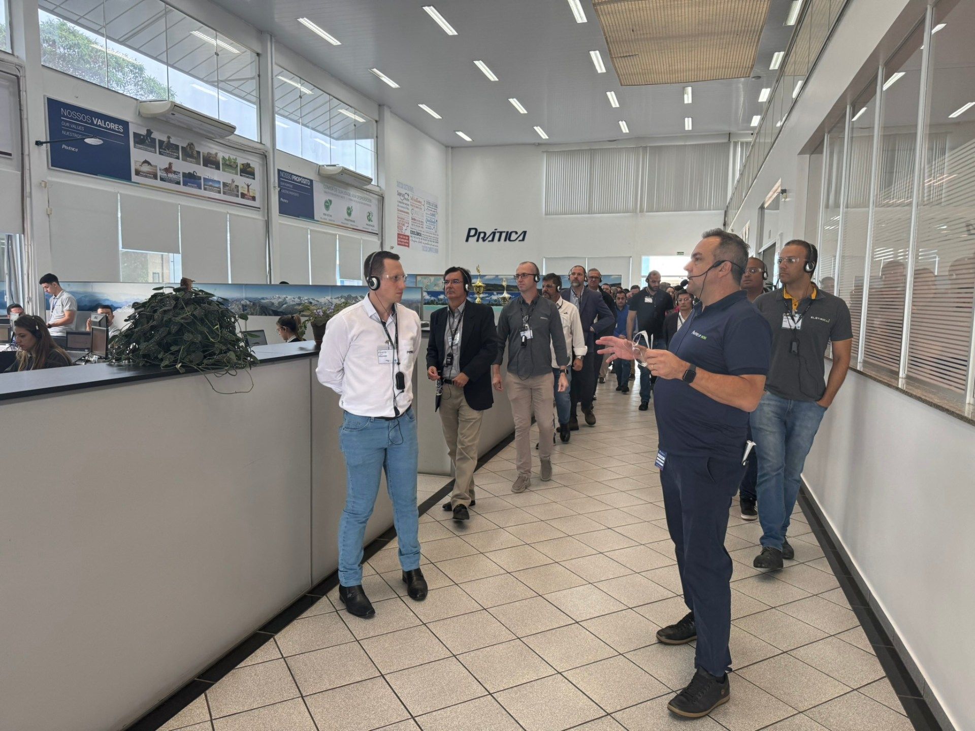 Um grupo de homens está parado em um corredor conversando entre si.