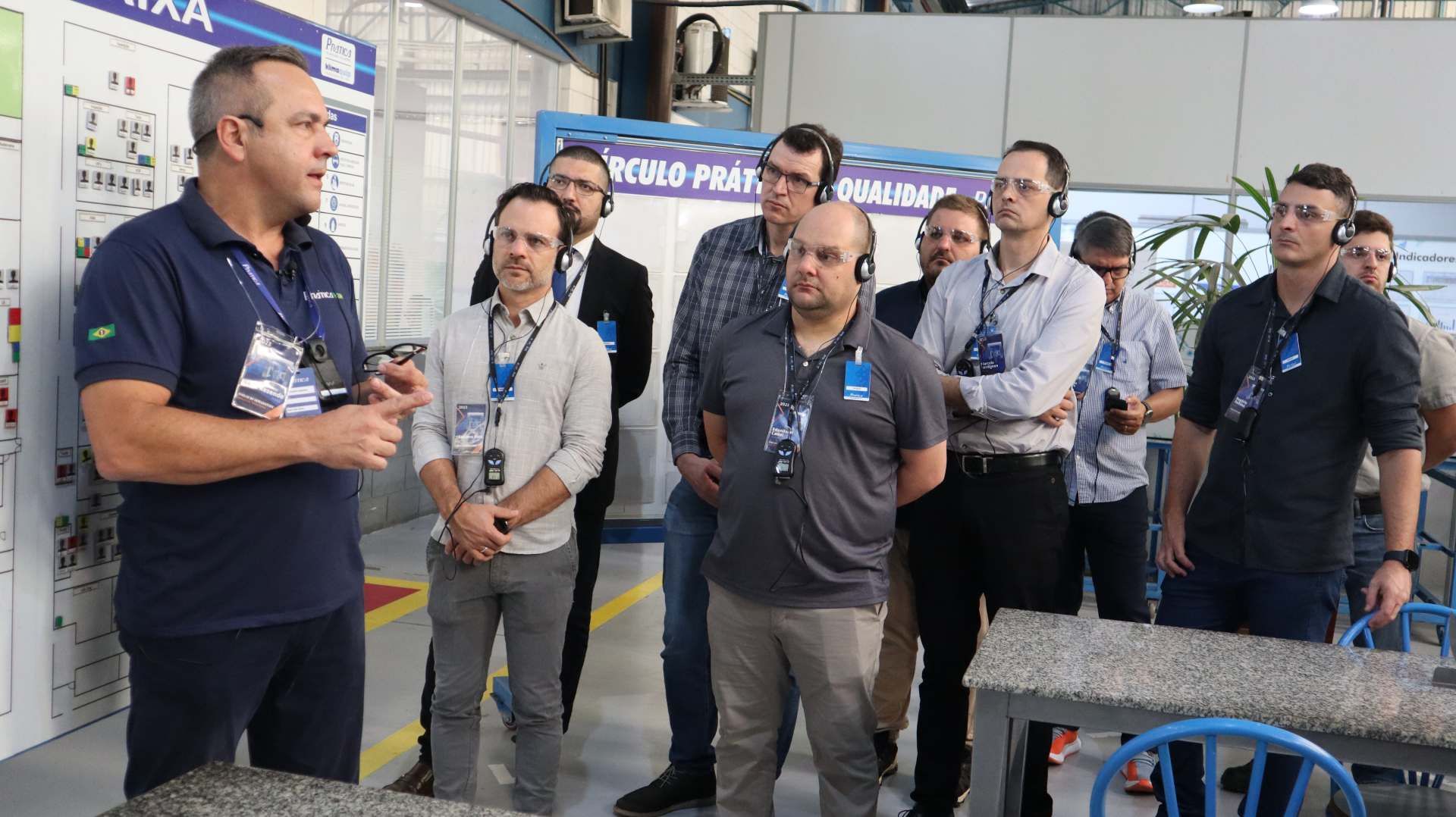 Um grupo de homens está em pé ao redor de uma mesa em uma sala.