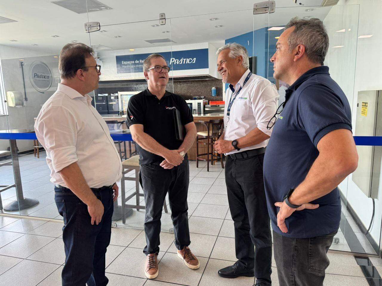 Um grupo de homens está em uma sala conversando entre si.