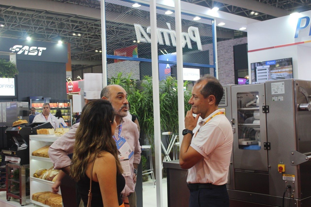 Um homem e uma mulher estão em frente a uma porta de vidro conversando.