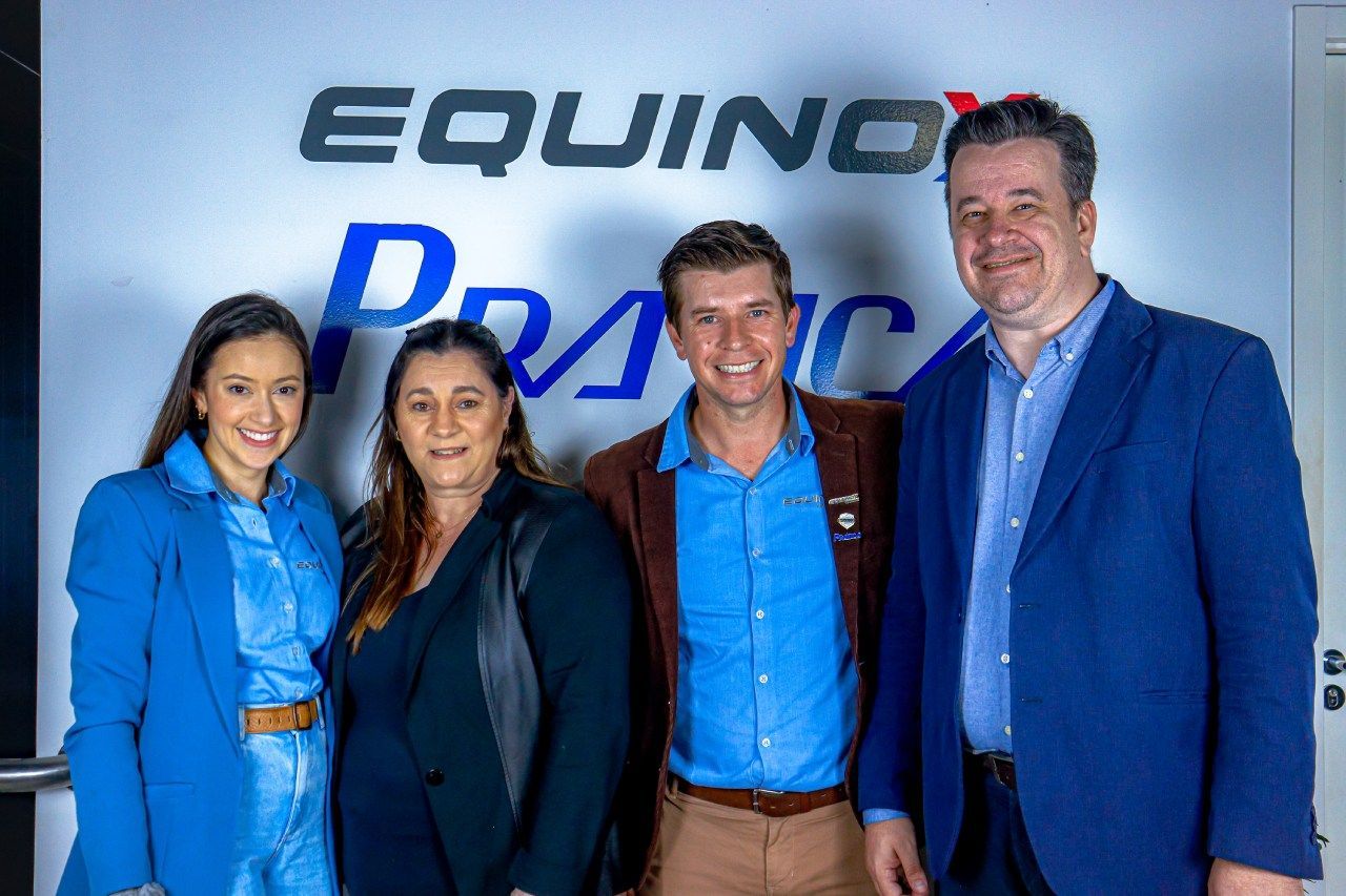 Um grupo de pessoas em pé na frente de uma placa que diz equinócio