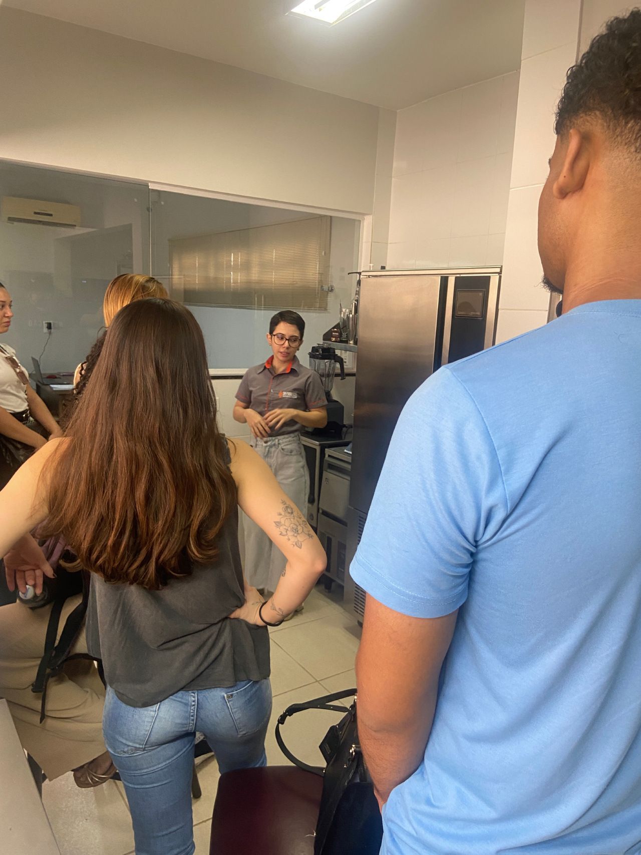 Um grupo de pessoas está em uma sala conversando entre si.