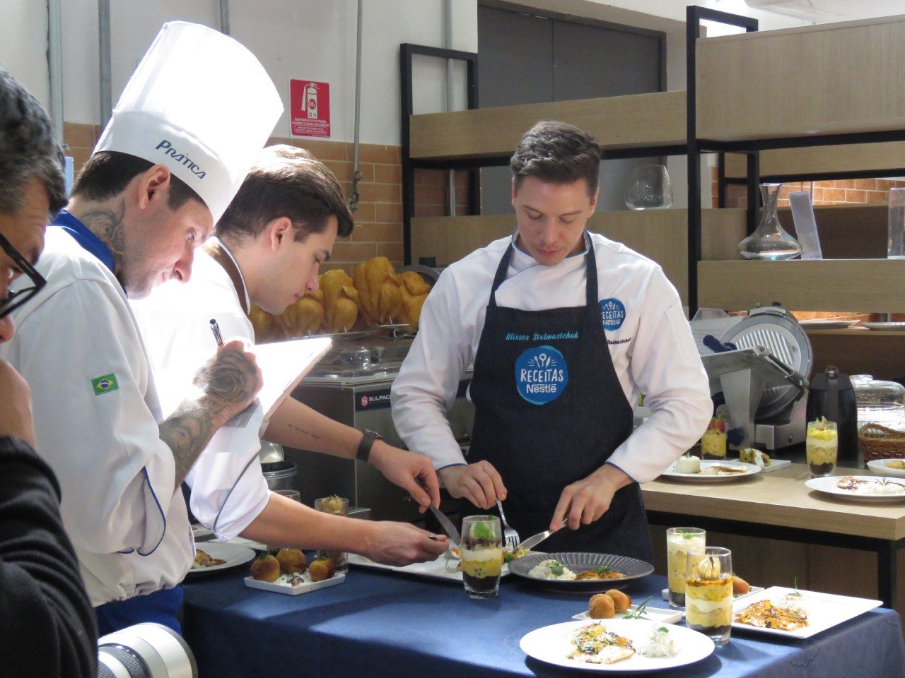 Um grupo de chefs está preparando comida em uma cozinha