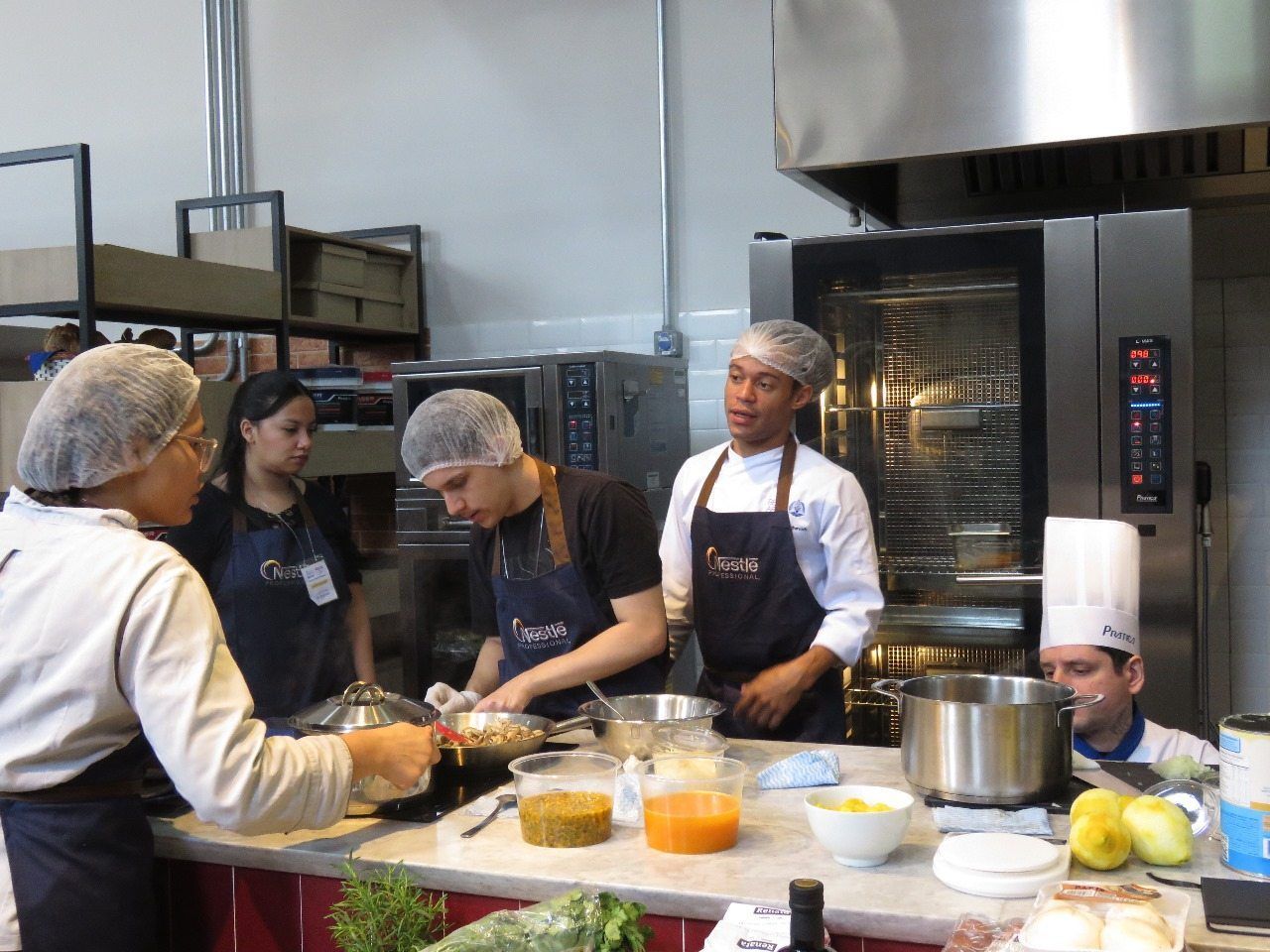 Um grupo de chefs está preparando comida em uma cozinha