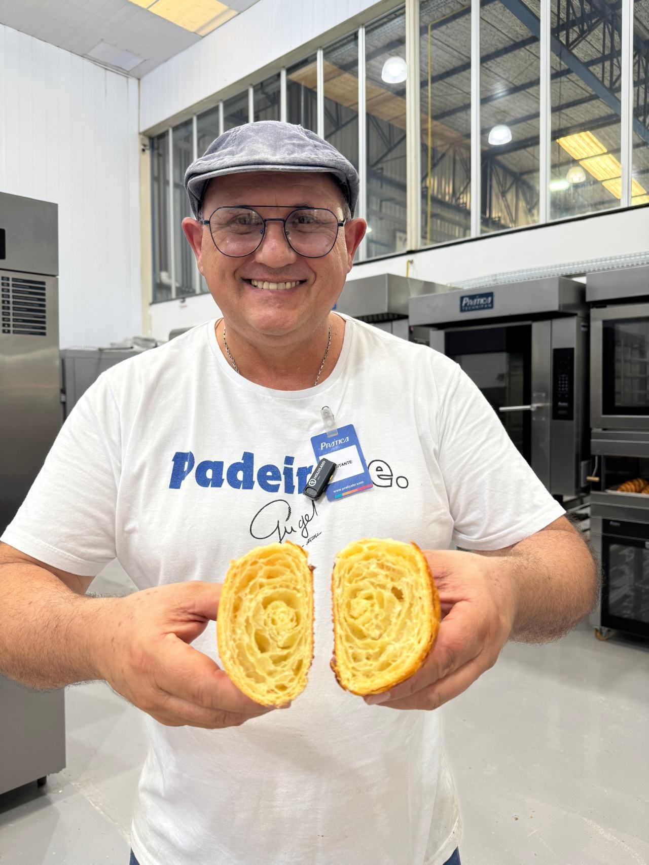 Um homem está segurando dois pedaços de pão nas mãos.