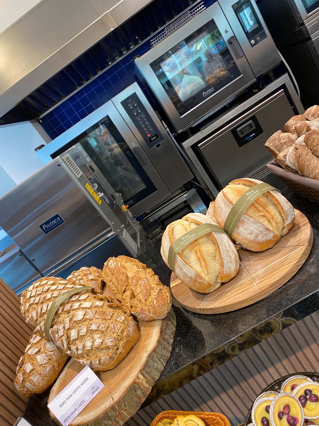 Um monte de pão está sobre uma mesa em uma padaria.