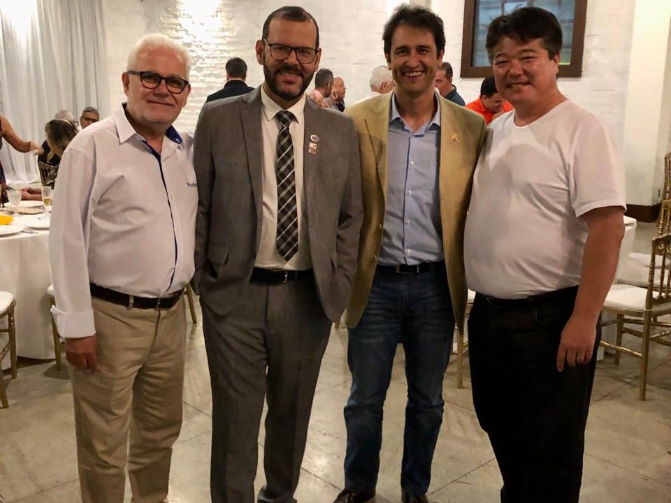 Um grupo de homens está posando para uma foto juntos em uma sala.
