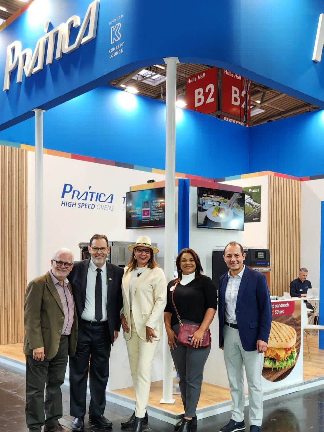 Um grupo de pessoas está posando para uma foto em frente a uma cabine.