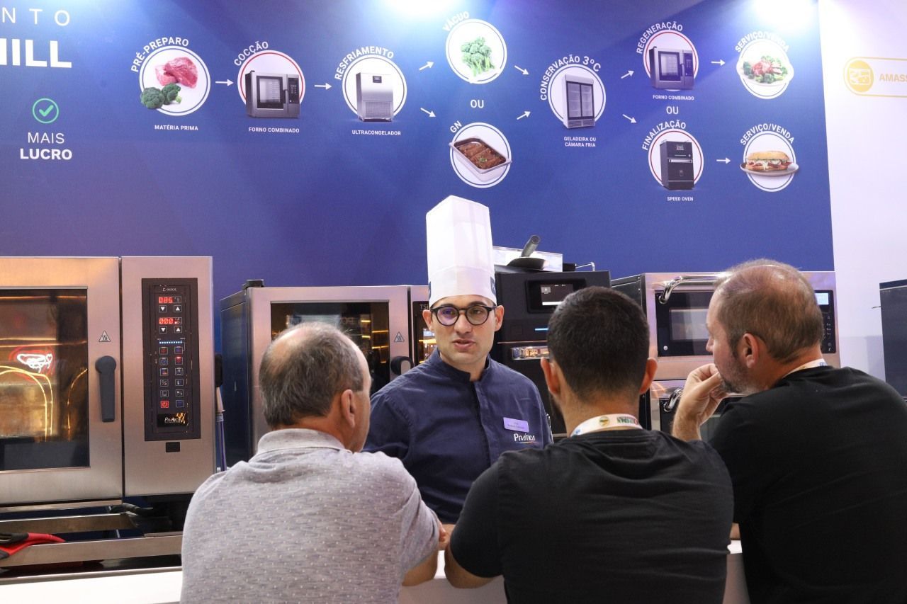 Um homem com chapéu de chef está conversando com um grupo de homens