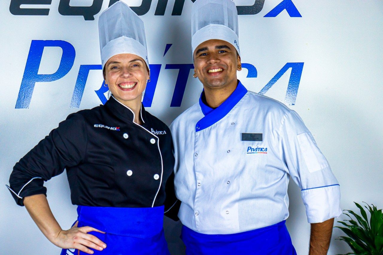 Um homem e uma mulher estão posando para uma foto em frente a uma placa que diz 'puro'