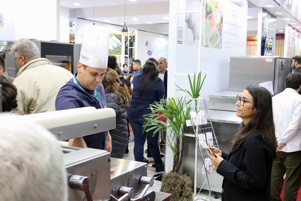 Um grupo de pessoas está em uma sala olhando para uma máquina.