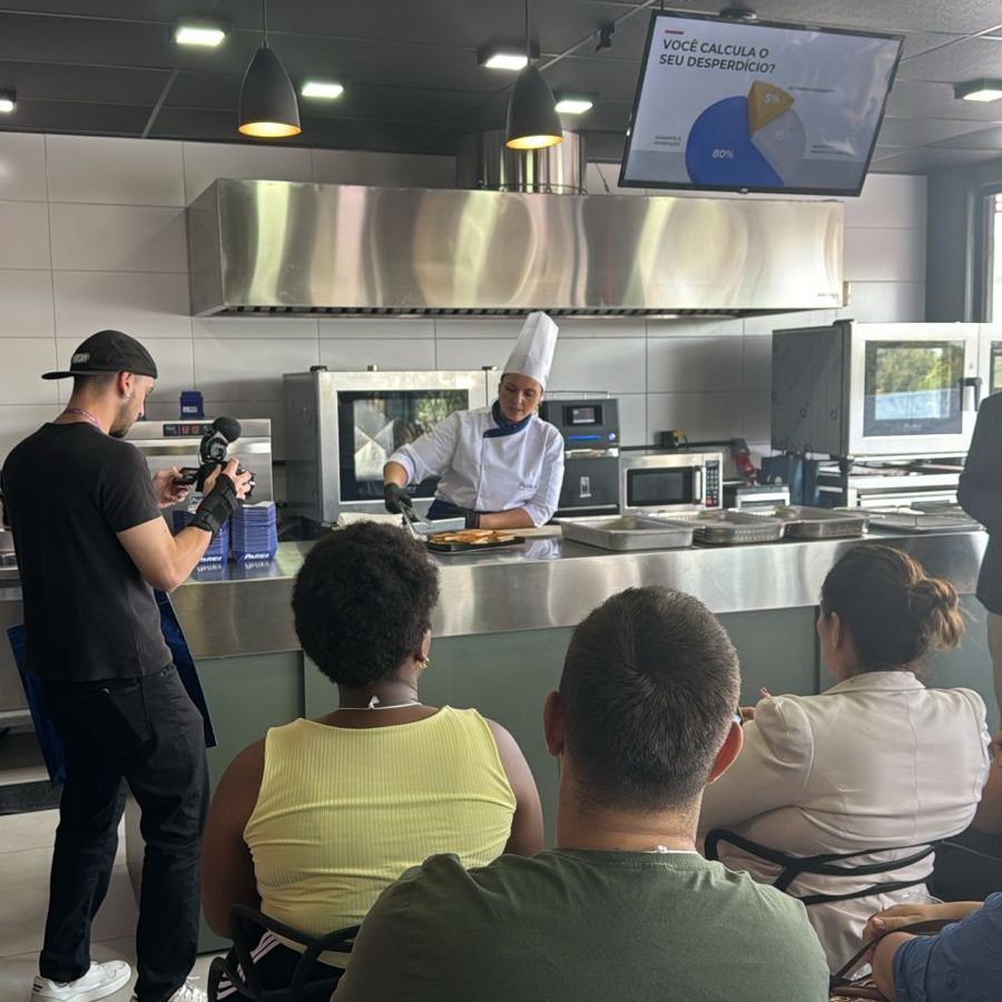 Um homem está tirando uma foto de um chef em uma cozinha