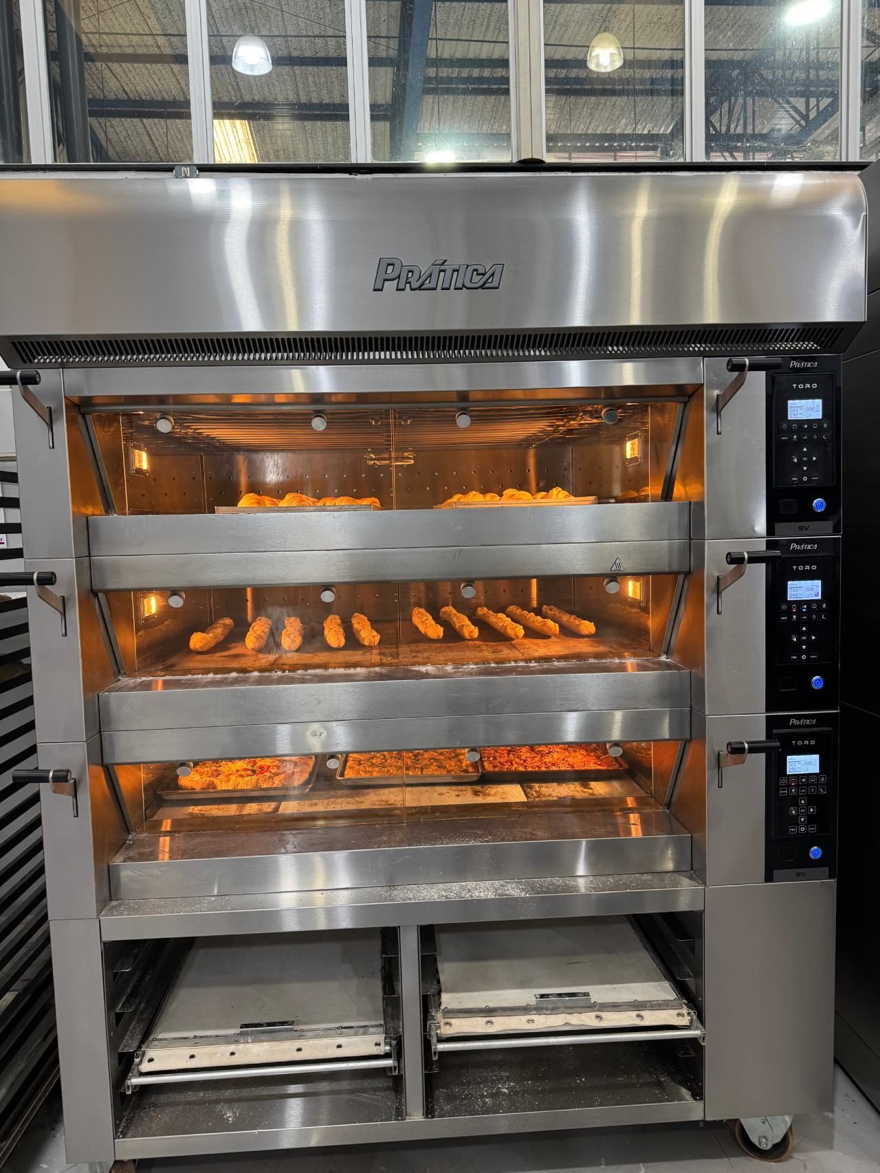 Um grande forno de aço inoxidável com um monte de comida dentro.