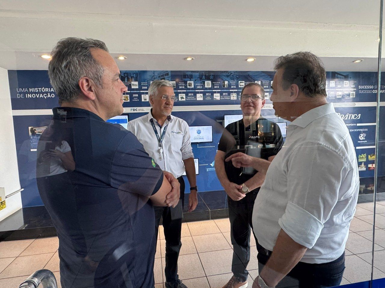 Um grupo de homens está em uma sala conversando entre si.