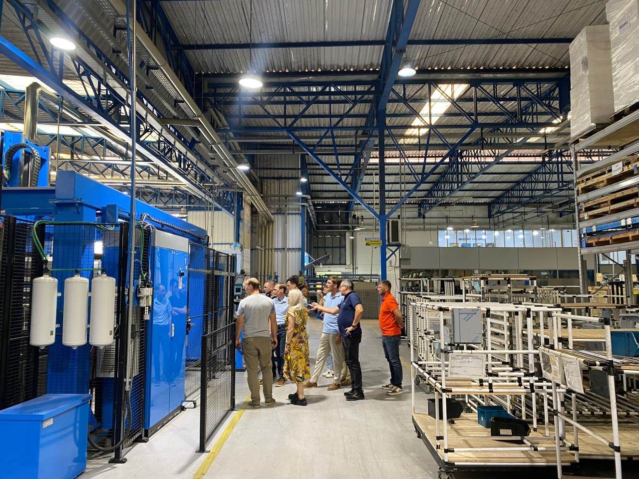 Um grupo de pessoas está em uma fábrica conversando entre si.