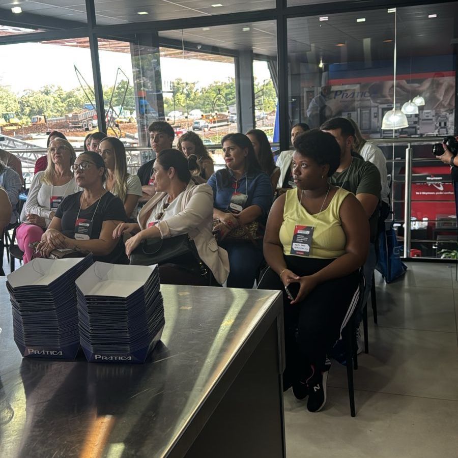 Um grupo de pessoas está sentado em uma sala assistindo a uma apresentação