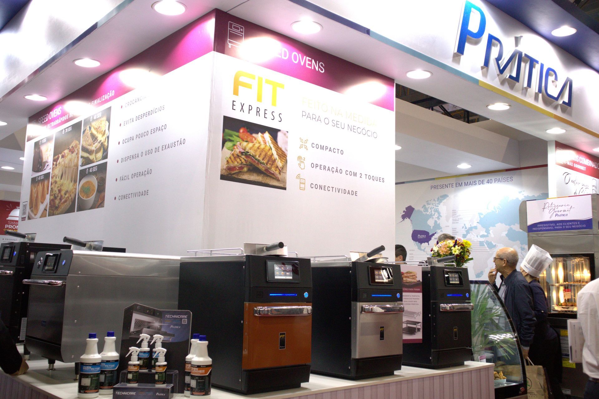 Um grupo de pessoas está em frente a um estande que diz fit express