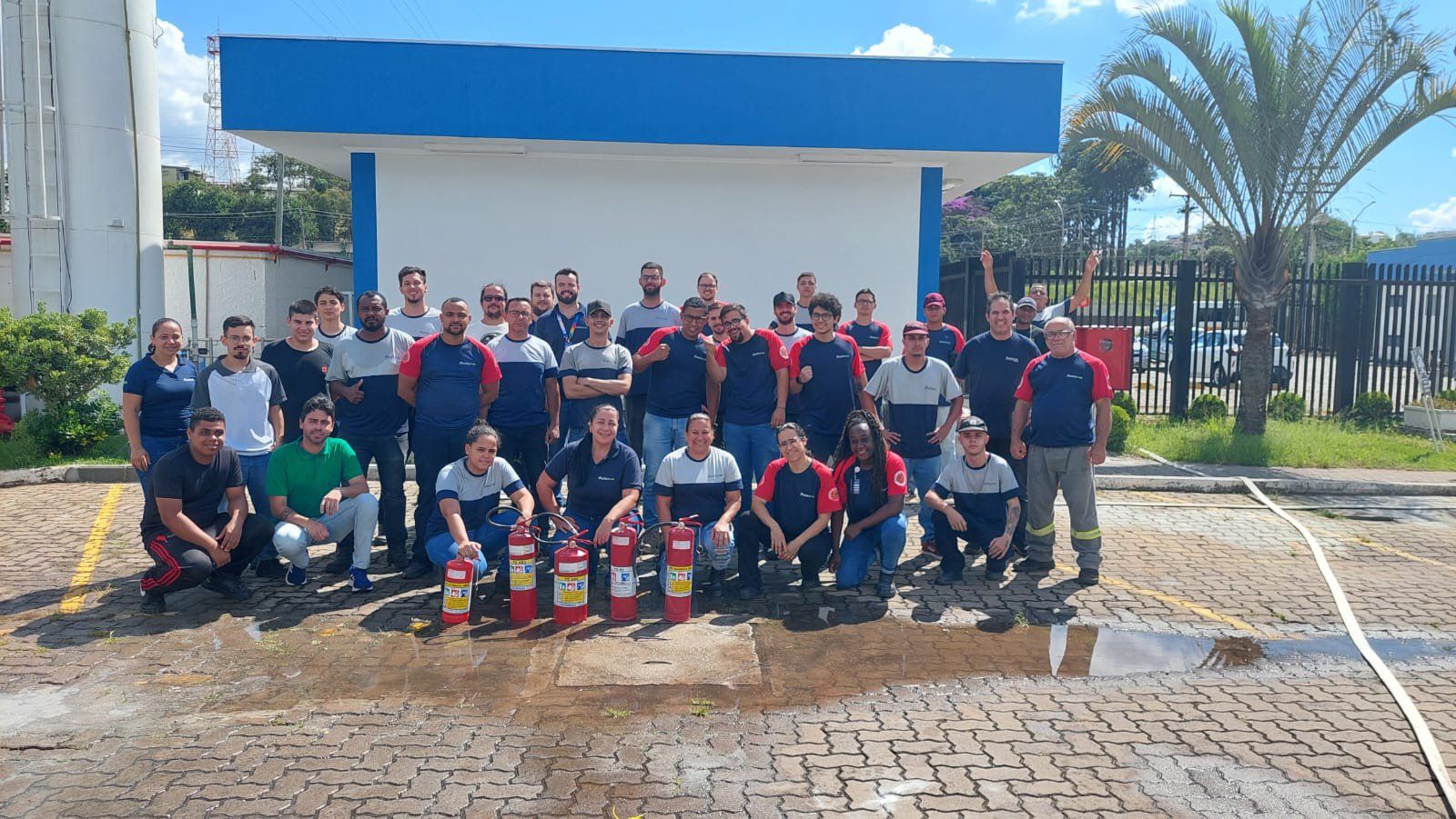Um grupo de pessoas está posando para uma foto em frente a um prédio.