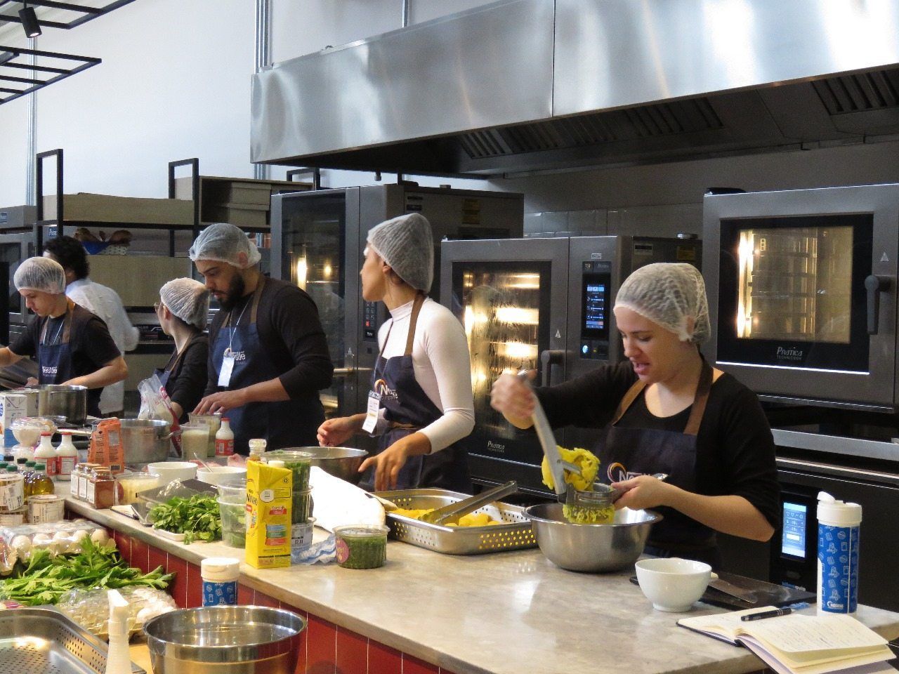 Um grupo de pessoas está preparando comida em uma cozinha.