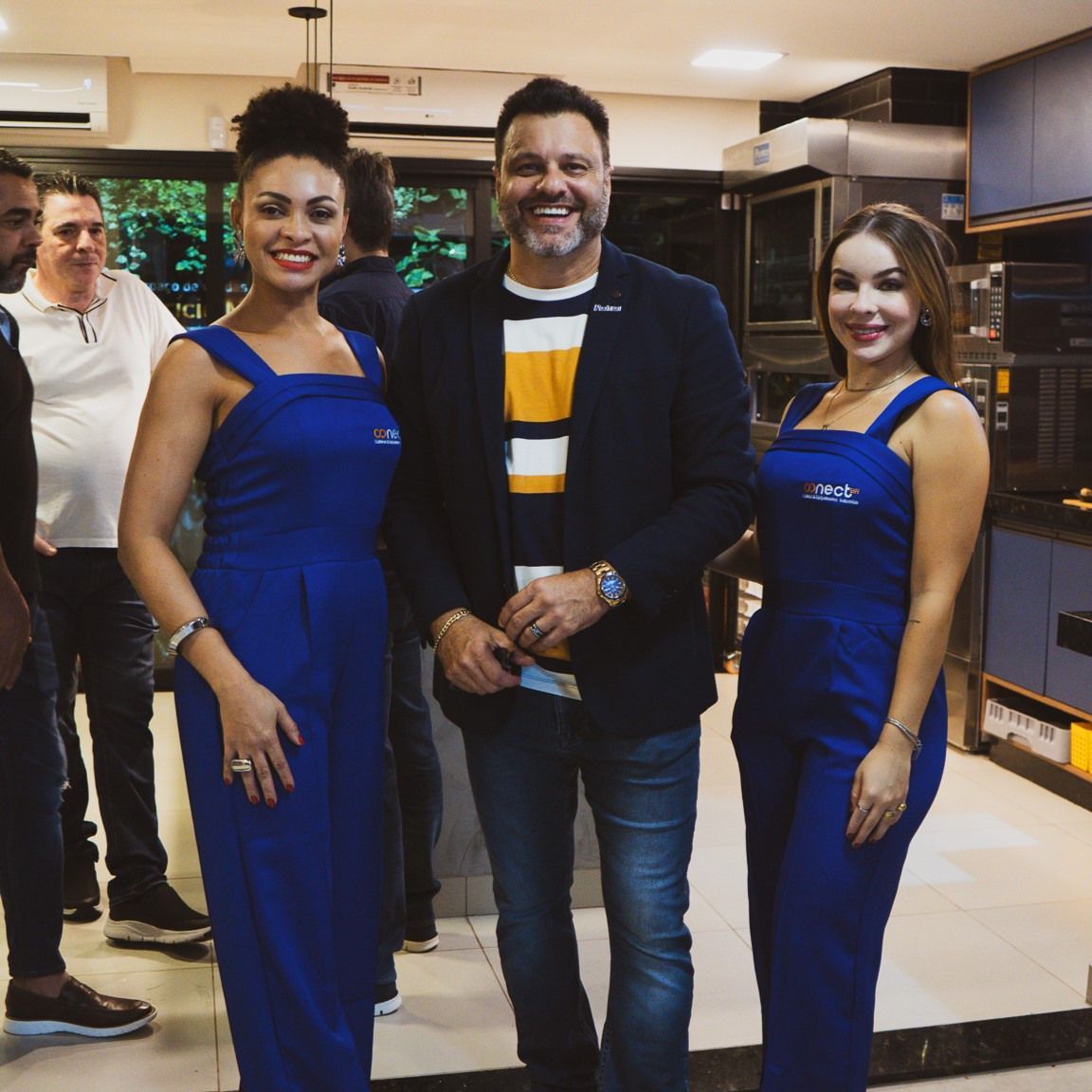 Um grupo de pessoas posando para uma foto em uma cozinha