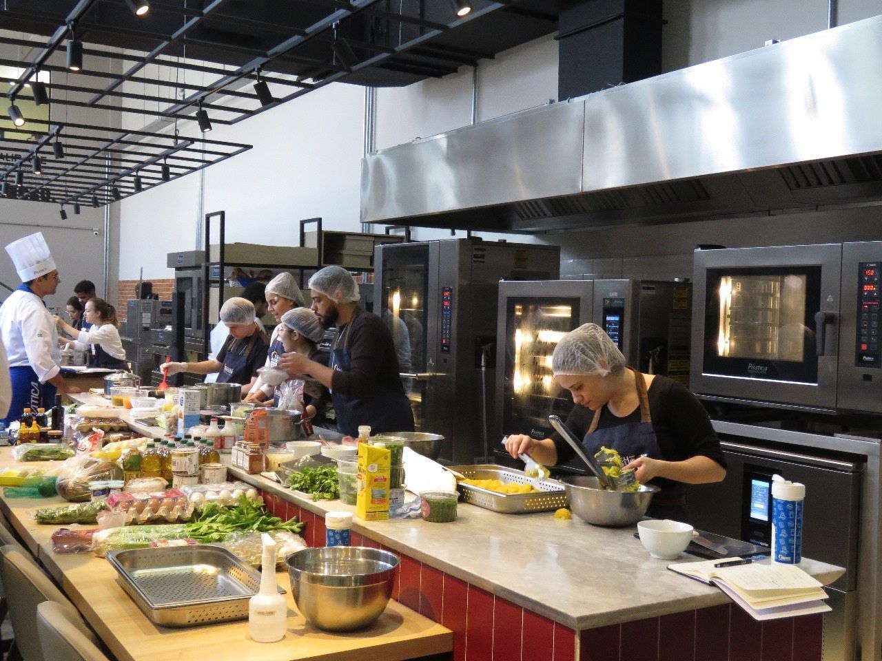 Um grupo de pessoas está preparando comida em uma cozinha