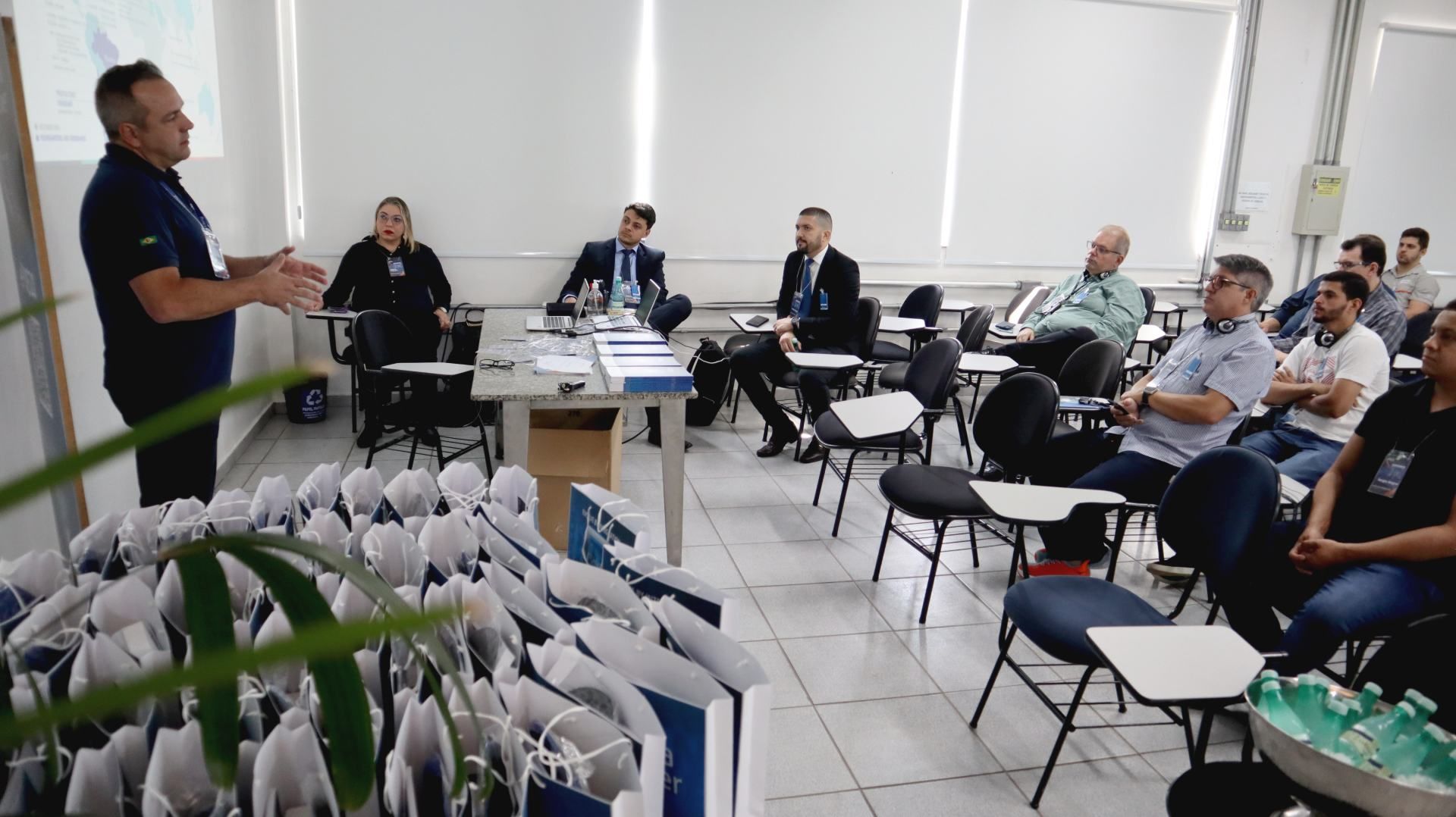 Um homem está fazendo uma apresentação para um grupo de pessoas em uma sala de aula.