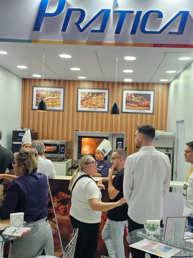 Um grupo de pessoas em pé na frente de uma placa de prática