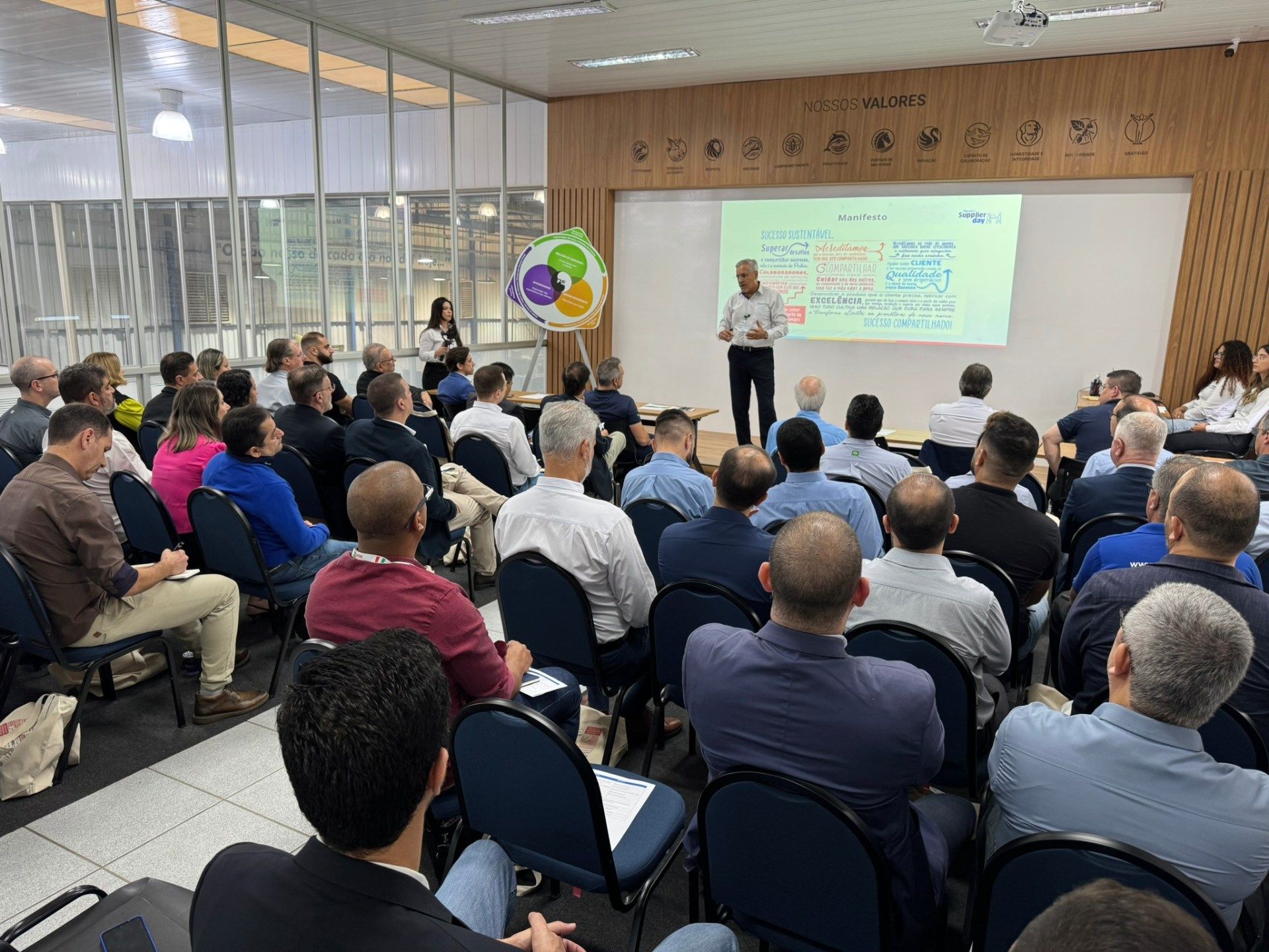Um homem está fazendo uma apresentação para um grupo de pessoas em uma sala de conferências.