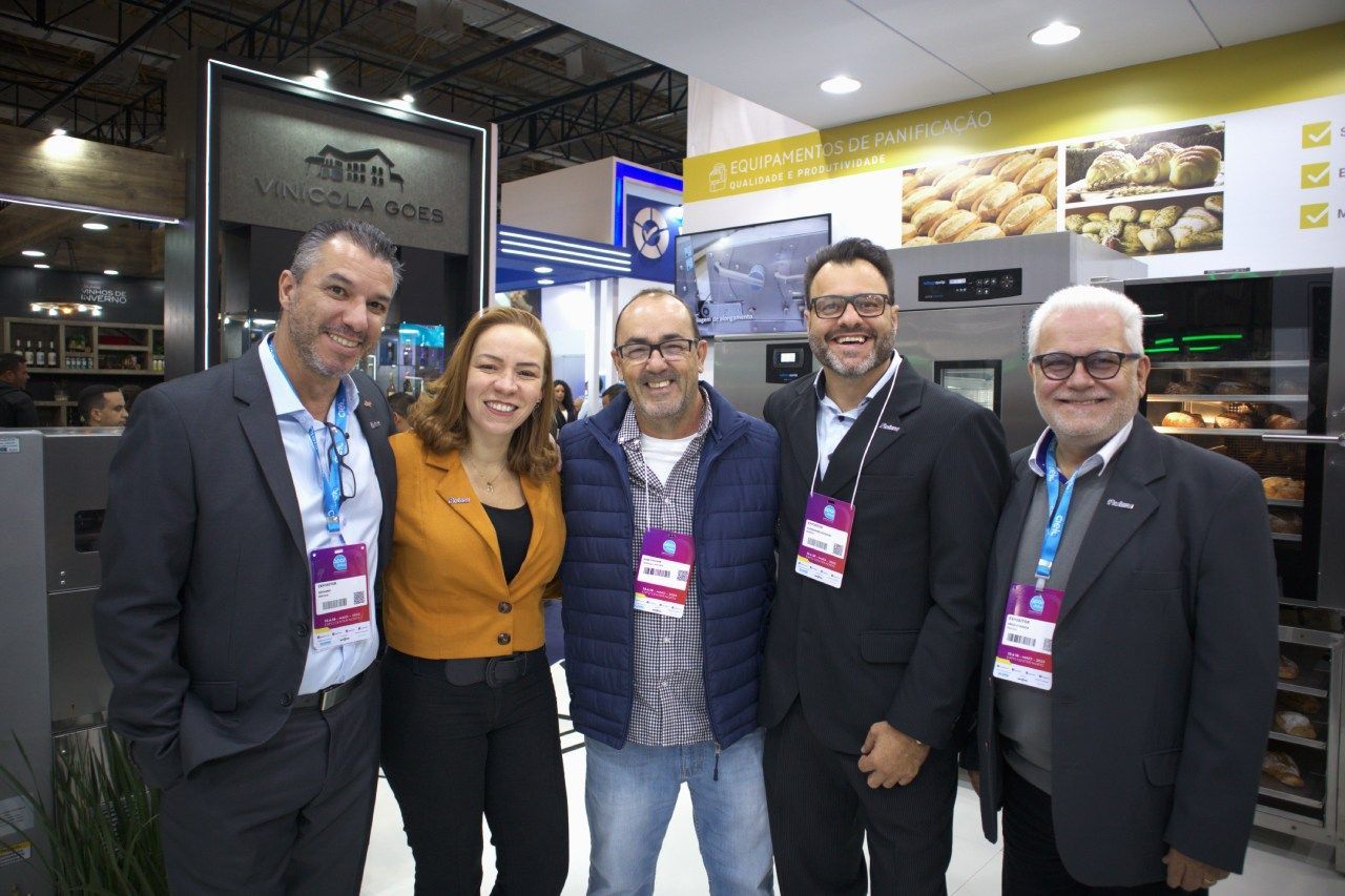 Um grupo de pessoas está posando para uma foto em uma padaria.