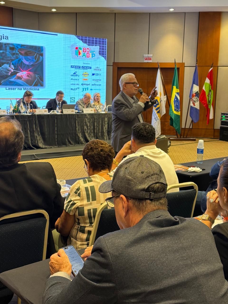 Um homem está fazendo uma apresentação para um grupo de pessoas em uma sala de conferências.