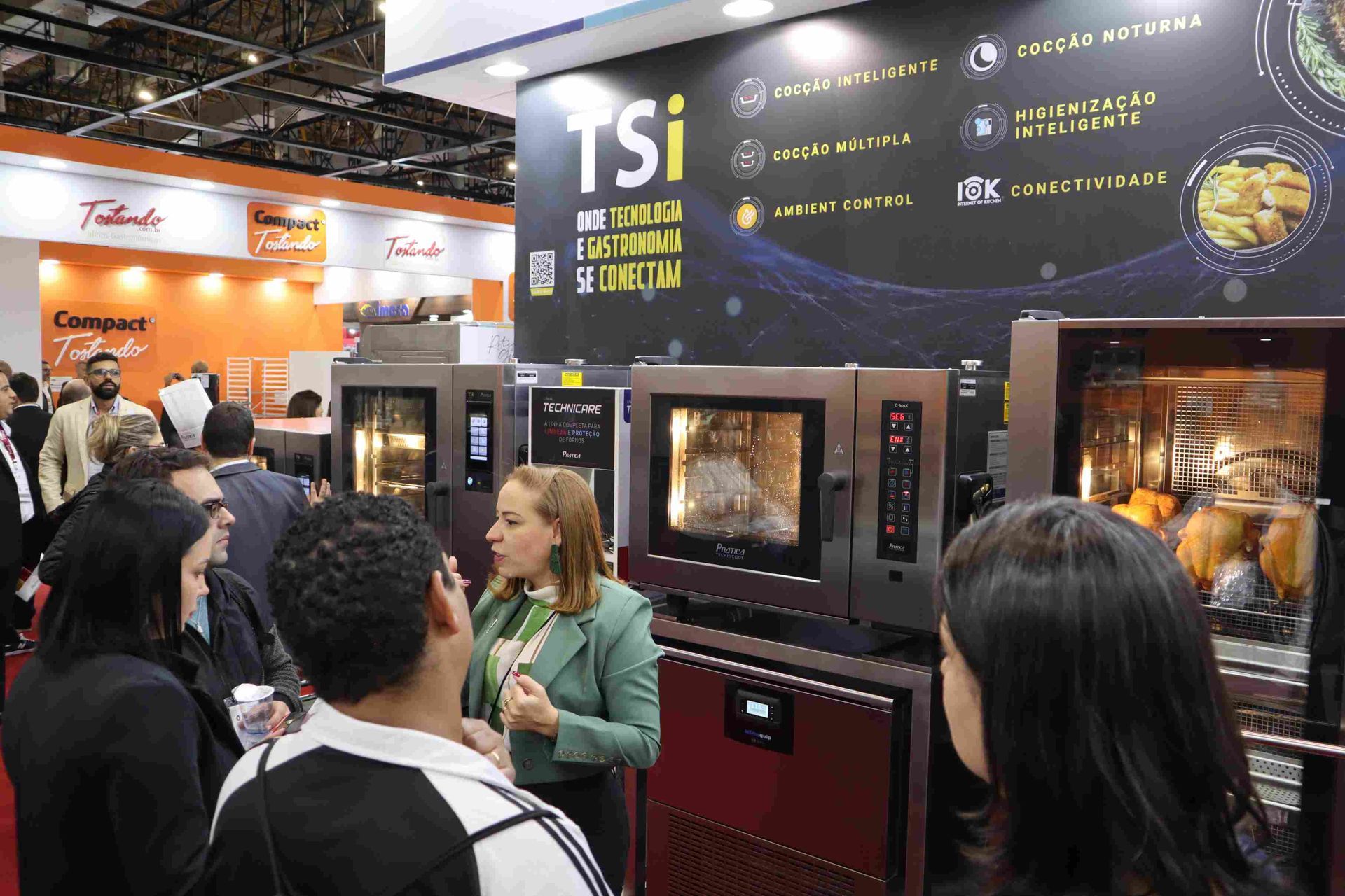 Um grupo de pessoas está em frente a uma placa que diz tsi.